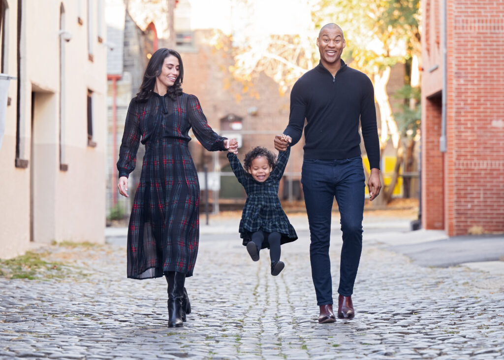 Court Street, Hoboken Family Photographer, Hoboken Children Photographer, New York City Family Photographer, Manhattan Family Photographer, Court Street Hoboken, Cobblestone Street, Fall Family Session, Child holding parents hand, Urban Family Session, Hoboken, Hudson County Photographer, Parents swinging child