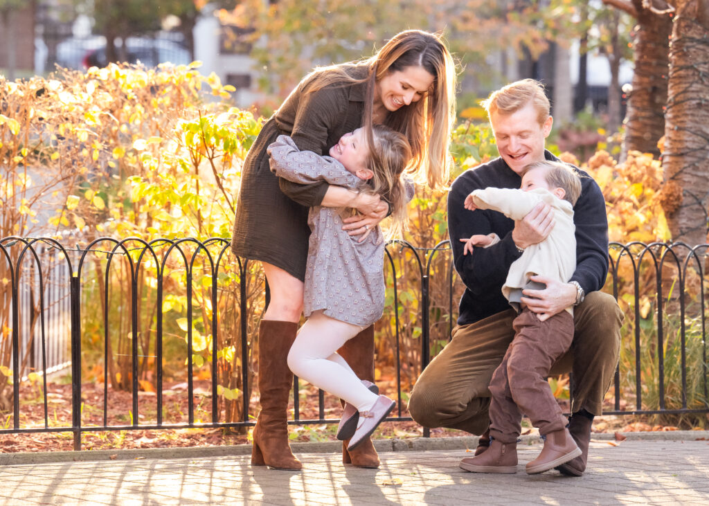 Family photo session in a park surrounded by fall colors. 

