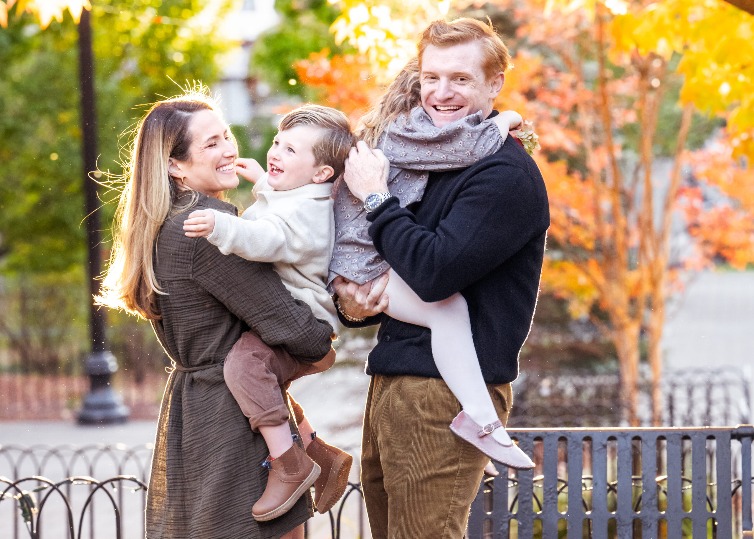Happy family photo surrounded by fall colors in a park in Hudson County New Jersey. 
